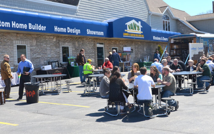 People sitting in tables and chairs gathered for an event at Van's Lumber